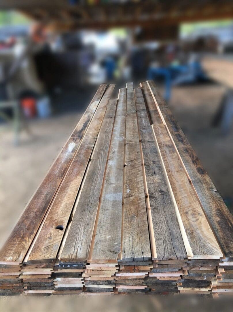 A stack of reclaimed wood planks in a workshop.