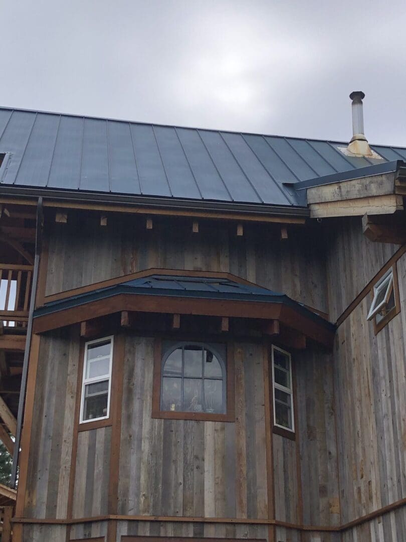 A house with a metal roof and wooden siding.